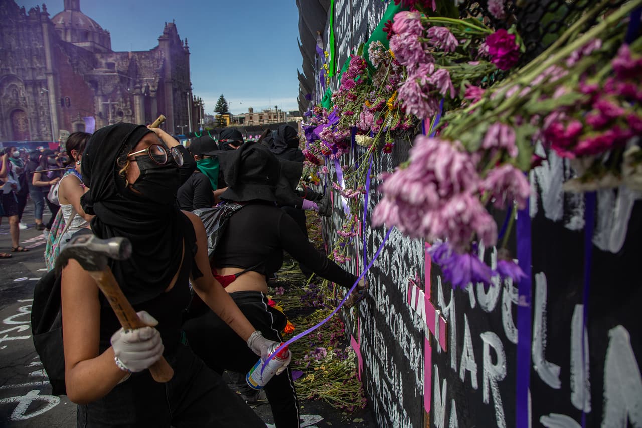 Las vallas de metal, además de pintadas, también fueron decoradas con cruces rosas y algunas flores en memoria de las 11 mujeres que mueren al día en México.
<br>