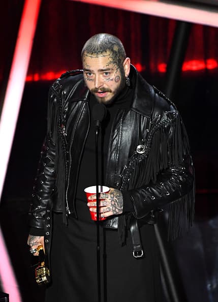 Post Malone fue el artista más galardonado con 9 premios y, aunque no brilló por su atuendo, su gabardina negra llena con el cinturón y su vaso en manos le da el toque rudo que todo rapero debe tener.