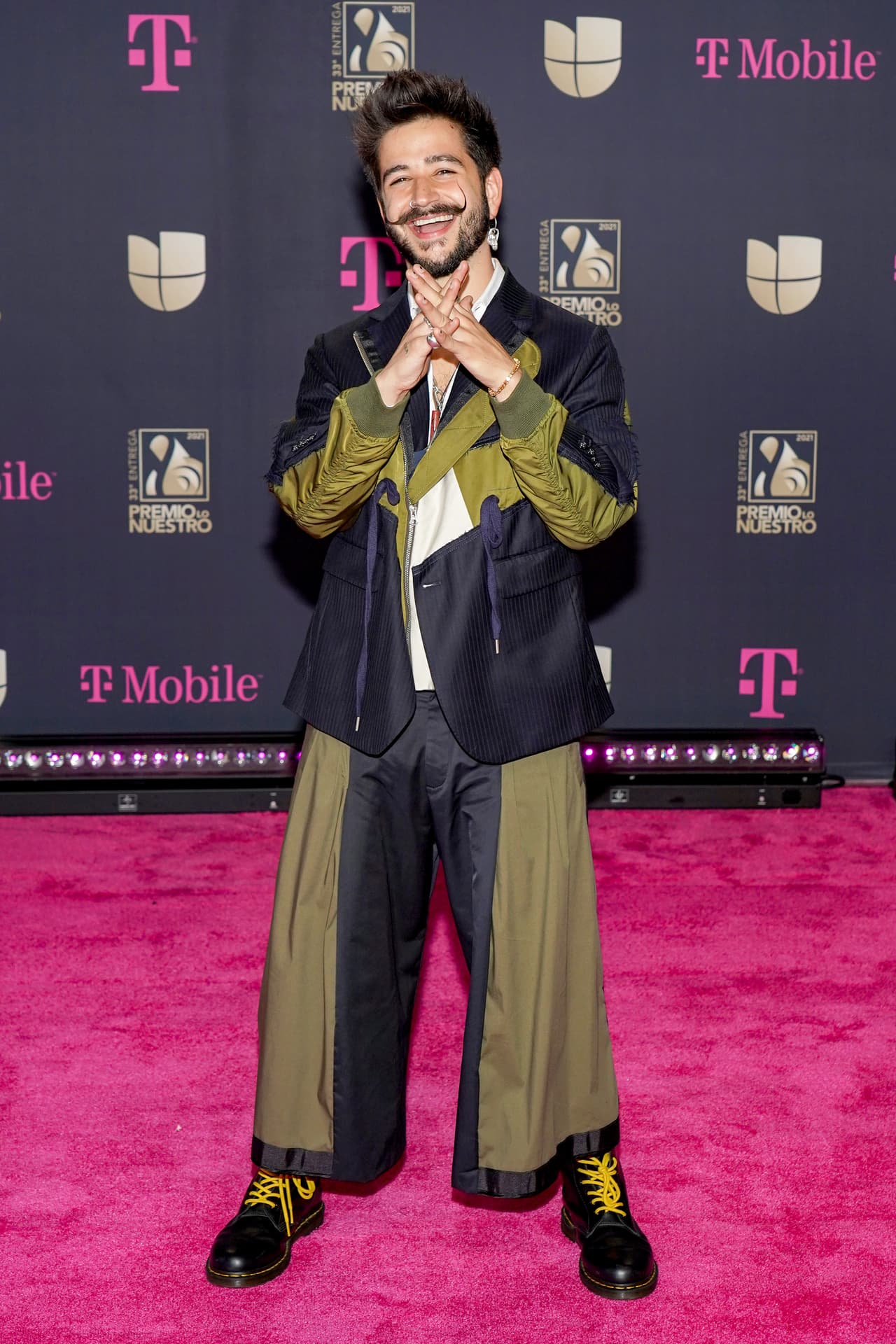 Camilo llegó con un traje con un corte holgado que combinaba el color negro con el verde militar. A juego con unas botas Dr Martens y su tradicional bigote, el intérprete de 'Ropa Cara' desfiló por la alfombra magenta muy emocionado.