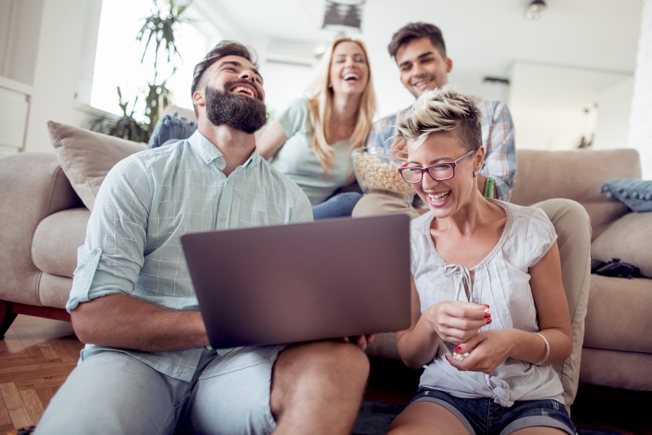 Group of friends enjoying time together and looking at the laptop.