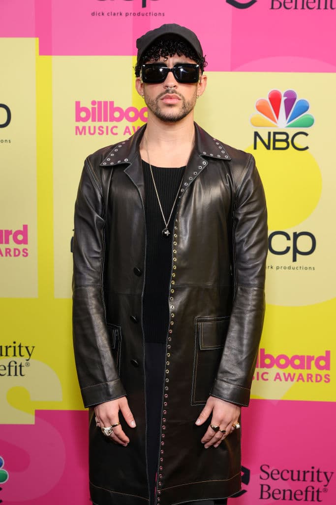 Bad Bunny lució un elegante atuendo color negro en una gabardina de piel, anillos en sus manos, lentes oscuros y un gorra del mismo tono.