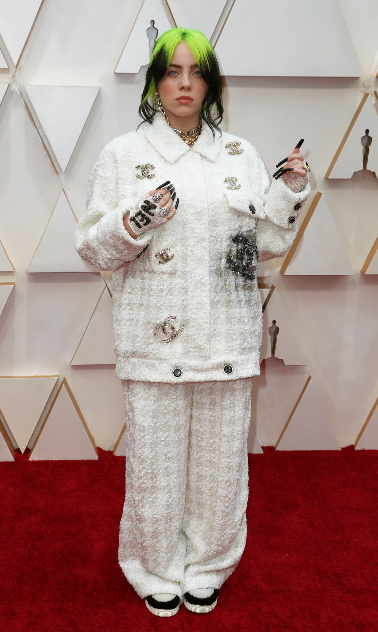 Nadie le dice a Billie Eilish cómo vestir. La intérprete ha impactado con su elección en moda, alejándose de los clichés del vestido largo de la típica estrella de pop; la estadounidense continúa usando ropa holgada y luciendóse con él: un traje blanco de Chanel, con referencias a la marca por todos lados, sus uñas negras y largas.