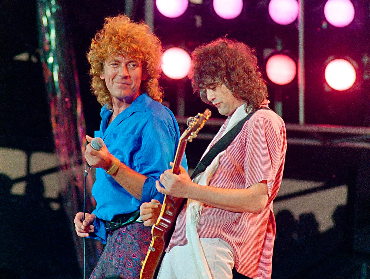 FILE - In this July 13, 1985 file photo, Led Zeppelin bandmates, singer Robert Plant, left, and guitarist Jimmy Page, reunite to perform for the Live Aid famine relief concert at JFK Stadium in Philadelphia. A U.S. appeals court on Friday, Sept. 28, 2018, ordered a new trial in a lawsuit accusing Led Zeppelin of copying an obscure 1960s instrumental for the intro to its classic 1971 rock anthem "Stairway to Heaven." (AP Photo/Amy Sancetta, File)