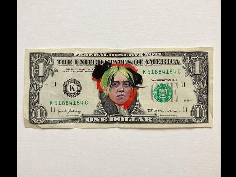Una artista llamada Claire Salvo mostró su talento con el pincel, transformando a diferentes celebridades en los protagonistas de los billetes de 1 dólar. Aquí podemos ver el resultado con Billie Eilish.