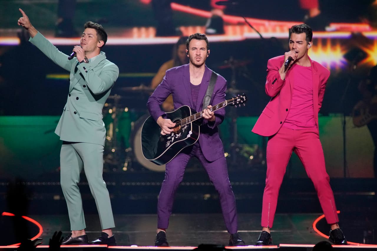 FILE - This Sept. 19, 2019 file photo shows Nick Jonas, from left, Kevin Jonas, and Joe Jonas, of the Jonas Brothers, performing during their "Happiness Begins Tour" in Chicago. The Jonas Brothers are set to perform on the iHeartRadio Jingle Ball Tour this holiday season. IHeartMedia announced Friday, Sept. 27, 2019, that the 12-city tour kicks off Dec. 1 in Tampa Bay, Florida. (Photo By Rob Grabowski/Invision/AP, File)