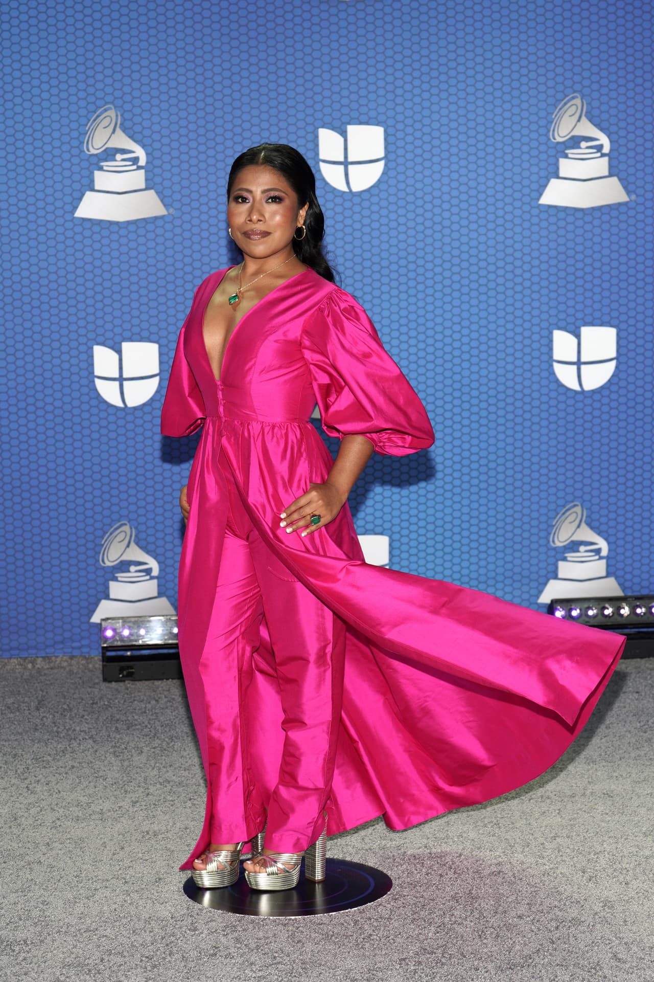 Yalitza Aparicio sorprendió con un look completo en color rosa mexicano, sin embargo, al caminar por frente a las cámaras, la actriz y conductora de evento dejó ver la sorpresa que escondía el modelo que lucía, y es que la parte superior del conjunto era tan solo la capa que cubría un pantalón de corte recto en el mismo color.