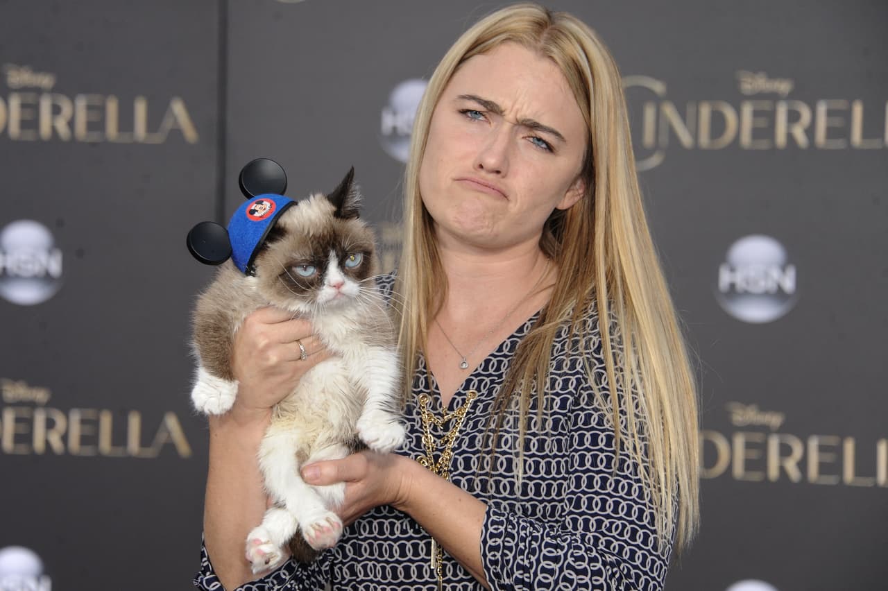 Tabatha Bundesen y Grumpy Cat posan en un evento.