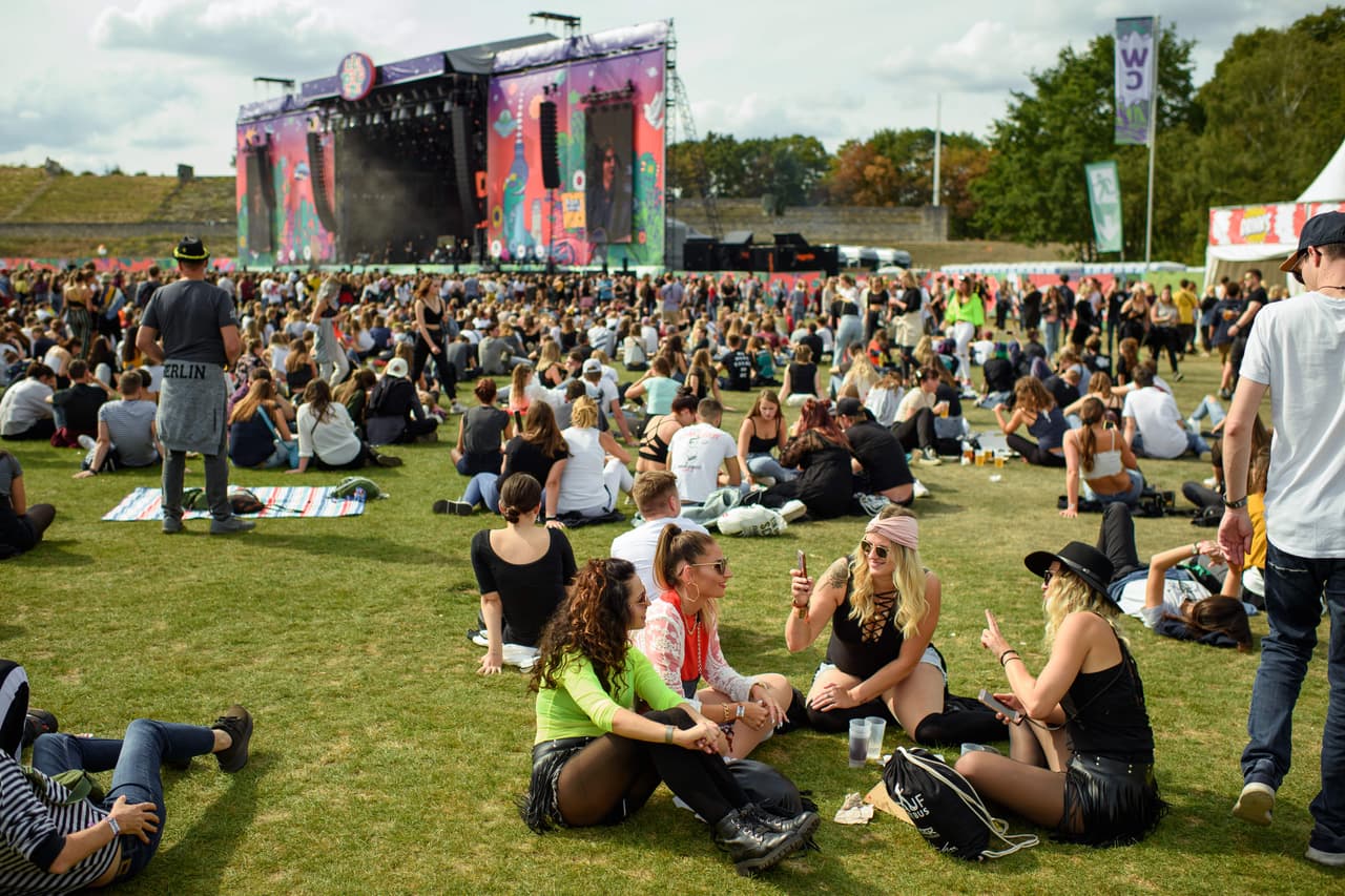 08 September 2019, Berlin: Visitors sit in a circle and take pictures of themselves with their smartphones during the Lollapalooza Festival in the Olympic Park. Photo: Gregor Fischer/dpa (Photo by Gregor Fischer/picture alliance via Getty Images)