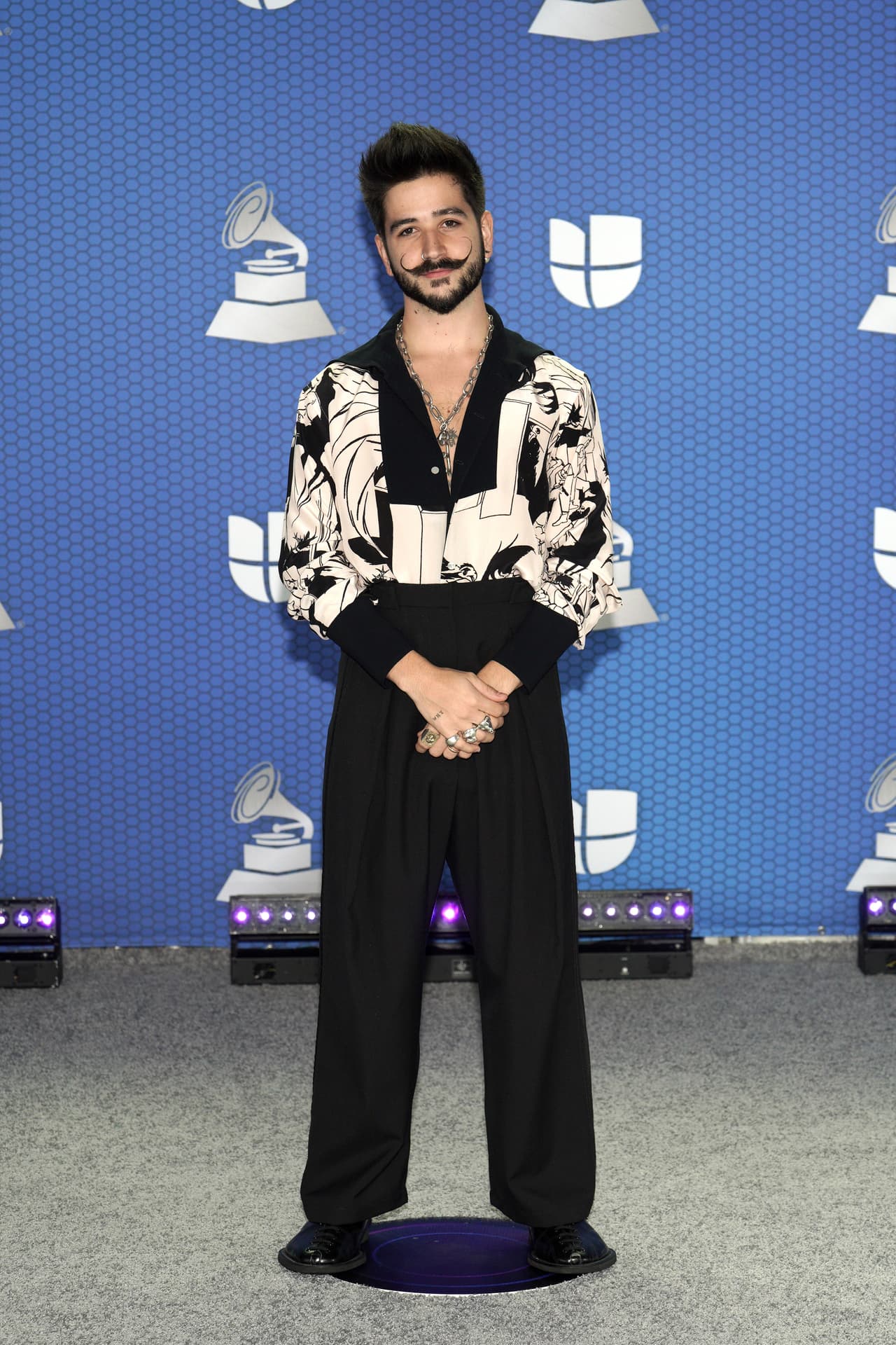 Con pantalones negros holgados a la cintura, Camilo fue uno de los artistas que más miradas se llevó. Sus anillos, su característico bigote y su camisa lo hicieron ver como la estrella que es.