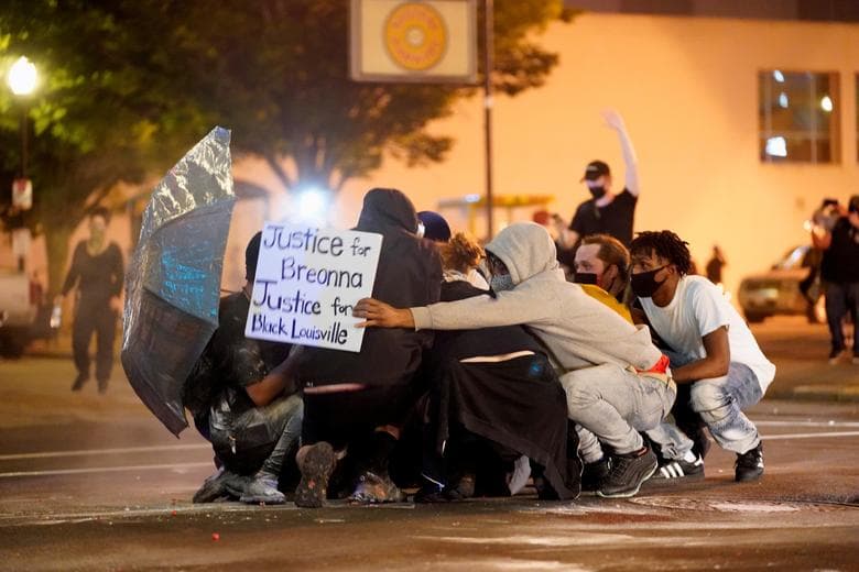 Kentucky, Estados Unidos.
<br>
<br>La gente se cubre de los disparos de las balas de goma.