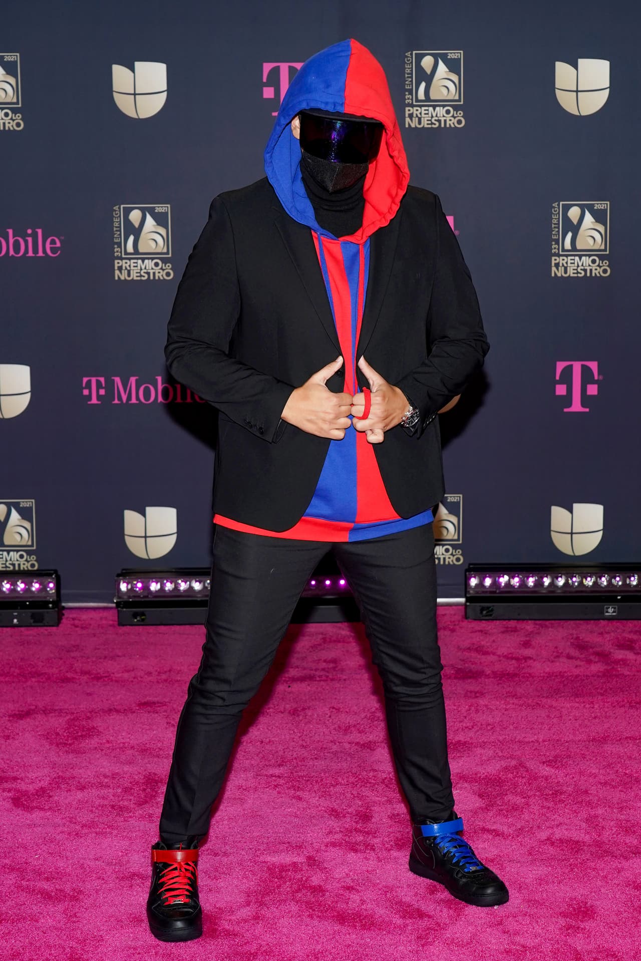KYEN?ES?, el misterioso cantante que siempre cubre su cara con gafas o accesorios grandes, llegó luciendo su característica combinación rojo y azul y los sumó a su traje negro para verse un poco más elegante.