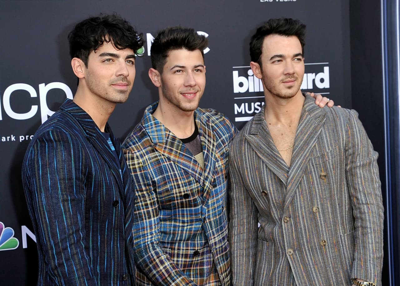 FILE - This May 1, 2019 file photo shows Joe Jonas, from left, Nick Jonas and Kevin Jonas, of the Jonas Brothers, at the Billboard Music Awards in Las Vegas. The brothers have signed a deal with Macmillan to publish their memoir. The book will delve into the band’s formation, rise to stardom, breakup in 2013 and reconciliation as a music group earlier this year. “Blood” will hit stores Nov. 12. (Photo by Richard Shotwell/Invision/AP, File)