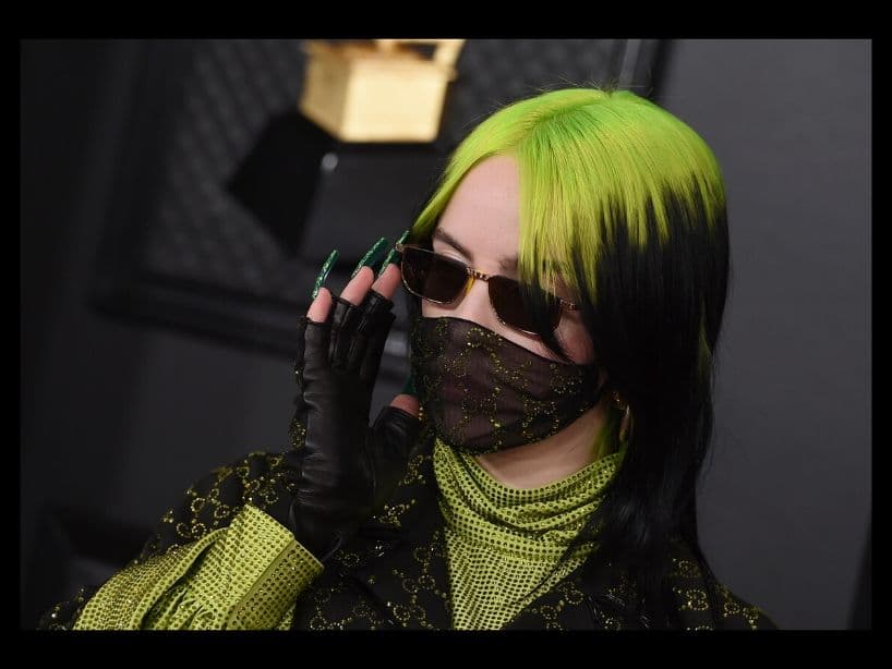 Uñas largas, lentes oscuros, cubrebocas, un traje Gucci con pedrerías que combinó con su cabello mitad verde y negro fue lo que se puso la cantante de 18 años.
