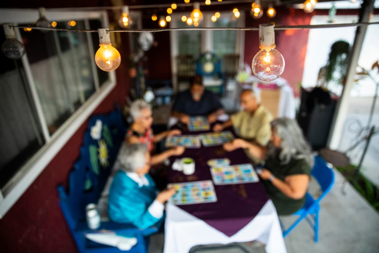 A mexican family playing a game after dinner.