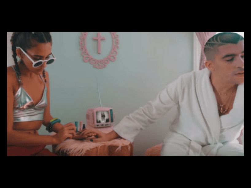 En los primeros segundos de su video “Caro”, Bad Bunny aparece sentado mientras una chica le pinta las uñas, demostrando que no p se hace menos hombre y tampoco se convierte en mujer.