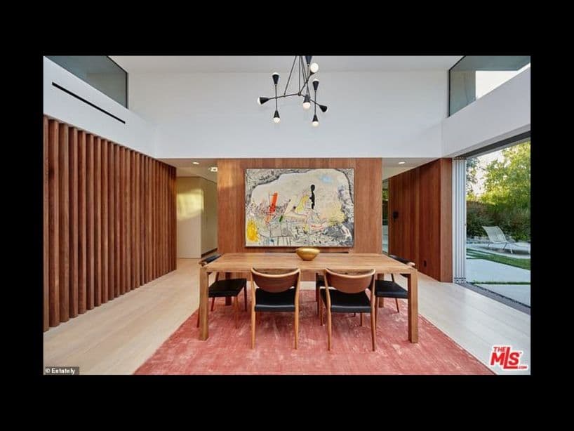 El estilo minimalista del comedor contrasta con el cuadro lleno de detalles.