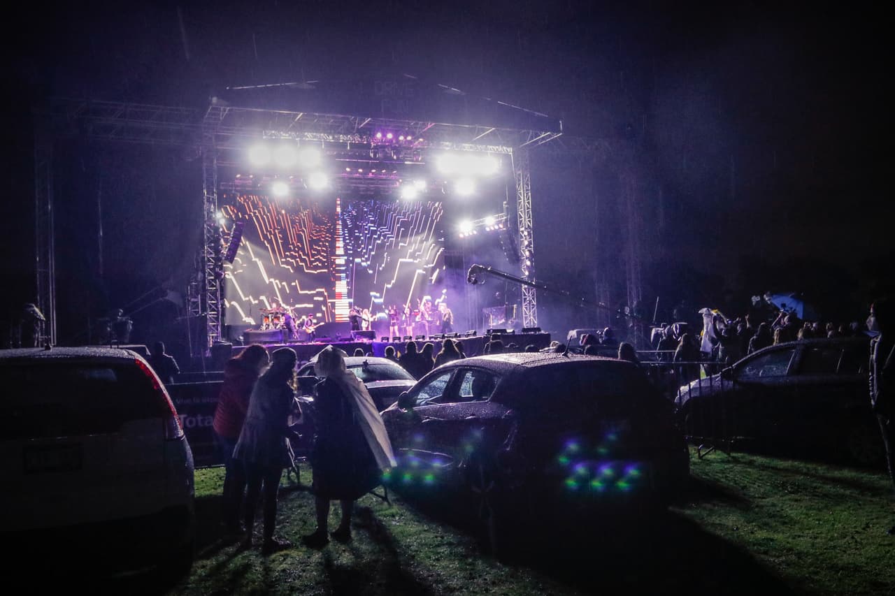 MEXICO CITY, MEXICO - JULY 30: People enjoy the concert outside their car within the assigned area, during a drive-in concert on July 30, 2020 in Mexico City, Mexico. The show presented by Ilse and Mimi is the first one of this type in Mexico City since the beginning of the Coronavirus (Covid-19) pandemic. (Photo by Medios y Media/Getty Images)