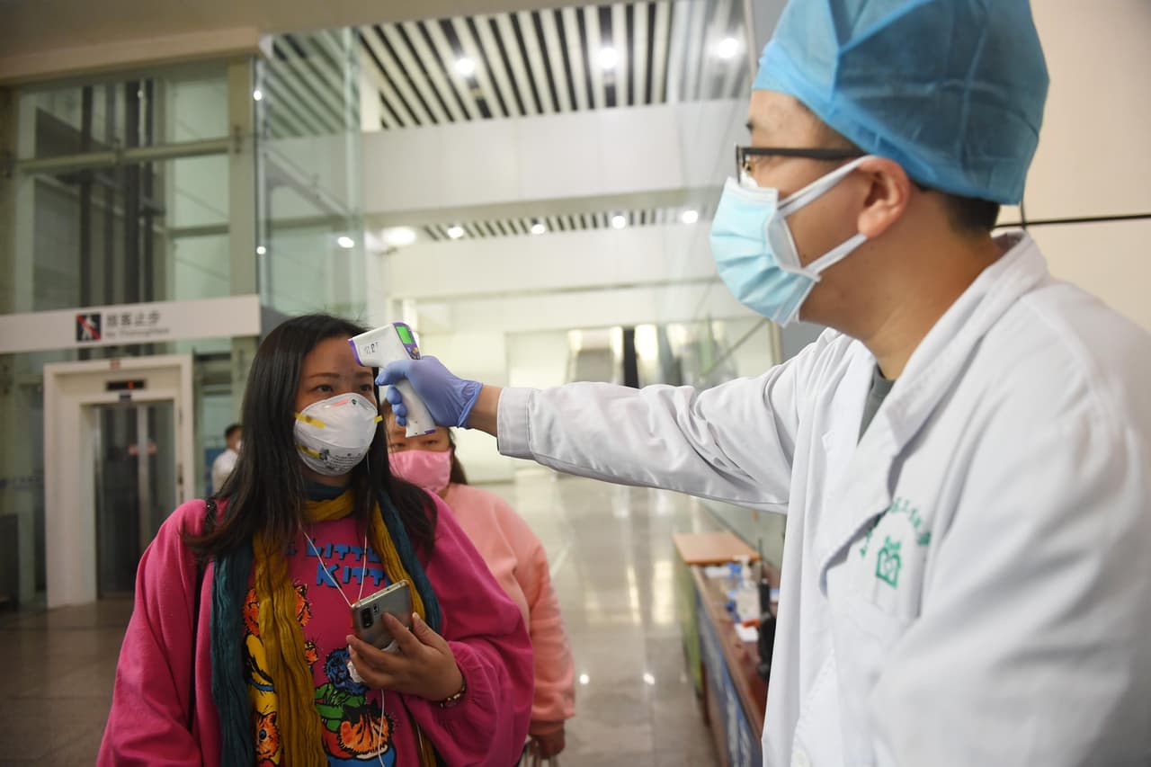 Como medida de prevención, a los habitantes de Wuhan todavía se les revisa la temperatura corporal después de llegar a la estación de tren de Guangzhou, el 8 de abril. Wuhan, la megaciudad en el centro de China, comenzó a levantar las restricciones de viaje después de casi 11 semanas de cierre.