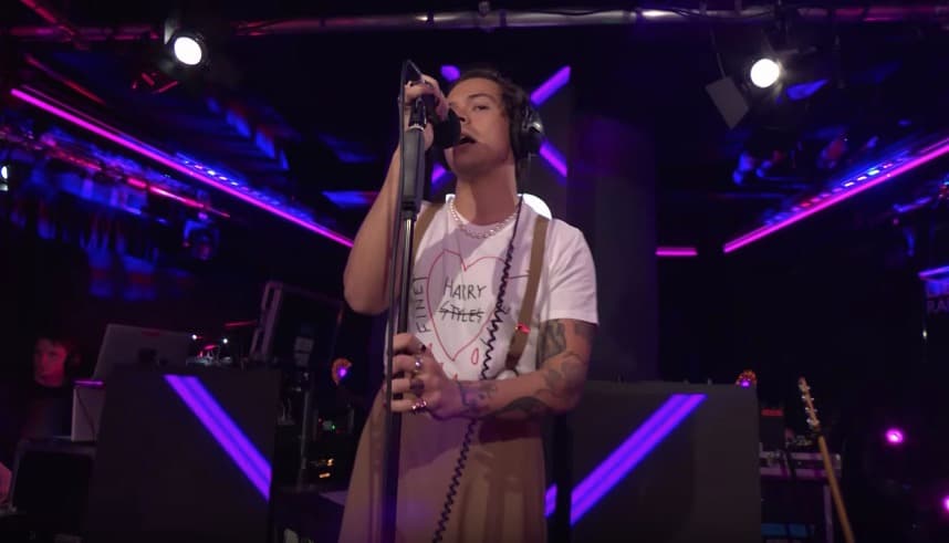 Durante su presentación en BBC Radio 1, Styles combinó su look de pantalones y tirantes monocromáticos con una playera que diseñó en colaboración con Alessandro Michel para Gucci. A esta combinación le agregó sus característicos anillos y un collar de perlas.