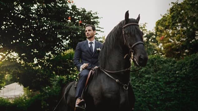El novio, quien es aficionado a la equitación, hizo una entrada muy emocionante al llegar al lugar montando un majestuoso caballo negro.