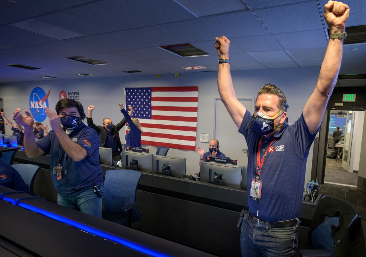 PASADENA, CA - FEBRUARY 18: In this handout image provided by NASA, members of NASA's Perseverance rover team react in mission control after receiving confirmation the spacecraft successfully touched down on Mars, , February 18, 2021 at NASA's Jet Propulsion Laboratory in Pasadena, California. A key objective for Perseverance's mission on Mars is astrobiology, including the search for signs of ancient microbial life. The rover will characterize the planet's geology and past climate, paving the way for human exploration of the Red Planet, and be the first mission to collect and cache Martian rock and regolith. (Photo by Bill Ingalls/NASA via Getty Images)